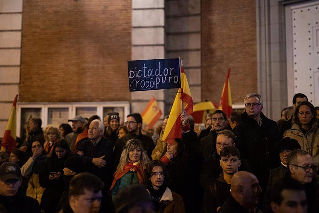 Several hundred people gather in front of the PSOE headquarters guarded by the Police
