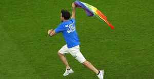 A fan invades the field with a rainbow flag during the Portugal-Uruguay World Cup